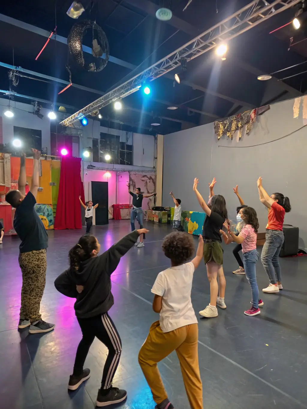 A vibrant image of a theatre workshop in progress, with participants actively engaged in acting exercises, showcasing the energy and collaborative spirit of GR2S GRAINES DE SALTIMBANQUE's programs.